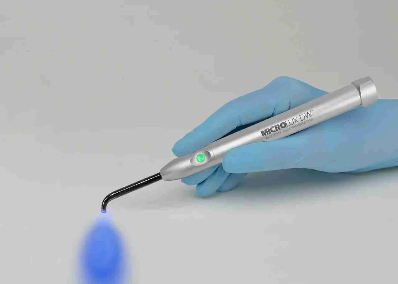 Transiluminador Microlux DW de AdDent en una mano con guante